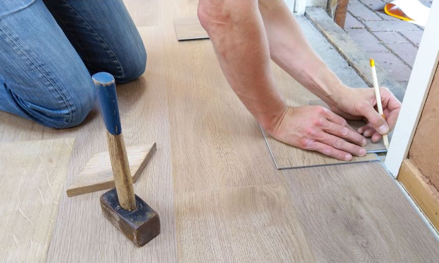 Bodendielen werden verlegt und mit dem Bleistift angezeichnet (Beispielfoto)